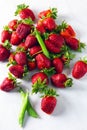 Fresh red strawberries and pods of green peas on white marble table Royalty Free Stock Photo