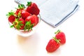Fresh red strawberries in transparent bowl and small kitchen towel isolated on white background Royalty Free Stock Photo