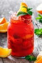 Fresh red strawberry lemonade with mint, orange and ice in glass jar on wooden background. Summer drinks and cocktails Royalty Free Stock Photo