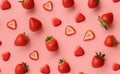 Fresh red strawberry on pink background, top view. Minimalistic scattered berries pattern