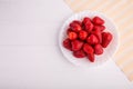 Fresh red strawberry on a white plate on a white background shot from above with copy space Royalty Free Stock Photo