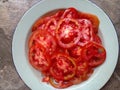 Fresh red tomatoes. Tomato slices laid out on a plate.