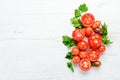 Fresh red tomatoes on white wooden background. Greens. Top view. Royalty Free Stock Photo