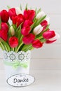 Fresh red tulip flowers bouquet on shelf in front of wooden wall Royalty Free Stock Photo