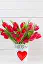 Fresh red tulip flowers bouquet on shelf in front of wooden wall Royalty Free Stock Photo