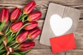 Fresh red tulips, blank frame and envelope Royalty Free Stock Photo