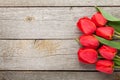 Fresh red tulips bouquet over wooden table background Royalty Free Stock Photo