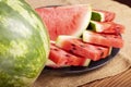 Fresh red watermelon pieces on a black plate on a wooden table. Sweet and juicy watermelon Royalty Free Stock Photo