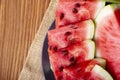 Fresh red watermelon pieces on a black plate on a wooden table. Sweet and juicy watermelon Royalty Free Stock Photo