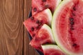 Fresh red watermelon pieces on a black plate on a wooden table. Sweet and juicy watermelon Royalty Free Stock Photo