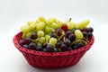 Fresh Red and White Grapes in a red basket isolated on white background Royalty Free Stock Photo