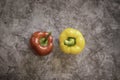 Red Bell and Yellow Bell Pepper on a Black Cement Background