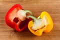 Fresh red and yellow bell pepper, cut one on wooden background Royalty Free Stock Photo