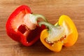 Fresh red and yellow bell pepper, cut one on wooden background Royalty Free Stock Photo