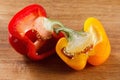 Fresh red and yellow bell pepper, cut one on wooden background Royalty Free Stock Photo