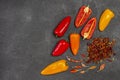 Fresh red and yellow peppers, nuts, dry pods and pepper petals on table