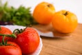 Fresh red and yellow tomatoes close up on a wooden board with a knife Royalty Free Stock Photo