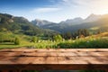 Fresh and relaxing scenery wooden table atop blurred mountains and grass