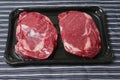 Fresh rib eye steak, Meat and food industry. Juicy premium cut of beef. Quality product on black plastic tray. Butcher craft