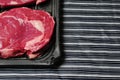 Fresh rib eye steak, Meat and food industry. Juicy premium cut of beef. Quality product on black plastic tray on black and white