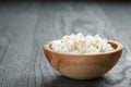 Fresh ricotta in olive wood bowl on old table