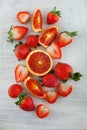 Fresh ripe blood oranges and strawberries, slices, rustic food photography on white wood plate