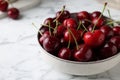 Fresh ripe cherries with water drops in bowl on white marble table, closeup Royalty Free Stock Photo