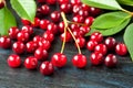 Fresh ripe cherry with green leaves on wooden background Royalty Free Stock Photo