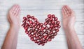 Fresh ripe cherry in shape of heart. Human hands and cherry berries in the shape of a heart. Health concept Royalty Free Stock Photo