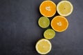 Fresh ripe citruses. Lemons, limes and oranges on dark stone background. Top view Royalty Free Stock Photo