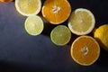 Fresh ripe citruses. Lemons, limes and oranges on dark stone background. Top view Royalty Free Stock Photo