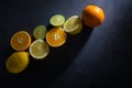 Fresh ripe citruses. Lemons, limes and oranges on dark stone background. Top view Royalty Free Stock Photo