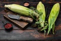 Fresh ripe corn cobs, on old dark  wooden table background Royalty Free Stock Photo