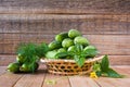 Fresh ripe cucumbers in a wicker plate on a wooden table