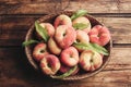 Fresh ripe donut peaches in basket on wooden table, top view Royalty Free Stock Photo