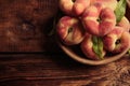 Fresh ripe donut peaches in bowl on wooden table, top view. Space for text Royalty Free Stock Photo