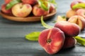 Fresh ripe donut peaches on grey wooden table, closeup. Space for text Royalty Free Stock Photo