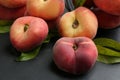 Fresh ripe donut peaches with leaves on dark table, closeup Royalty Free Stock Photo