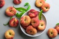 Fresh ripe donut peaches with leaves on light table, flat lay Royalty Free Stock Photo
