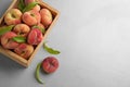 Fresh ripe donut peaches with leaves on light table, flat lay. Space for text Royalty Free Stock Photo