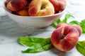 Fresh ripe donut peaches with leaves on white marble table, closeup Royalty Free Stock Photo