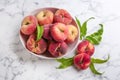 Fresh ripe donut peaches with leaves on white marble table, flat lay Royalty Free Stock Photo