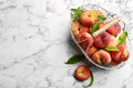 Fresh ripe donut peaches with leaves on white marble table, flat lay. Space for text Royalty Free Stock Photo