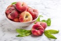 Fresh ripe donut peaches with leaves on white marble table Royalty Free Stock Photo