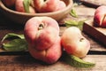 Fresh ripe donut peaches with leaves on wooden table, closeup Royalty Free Stock Photo