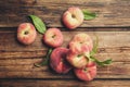 Fresh ripe donut peaches with leaves on wooden table, flat lay Royalty Free Stock Photo