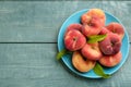 Fresh ripe donut peaches on light blue wooden table, top view. Space for text Royalty Free Stock Photo