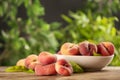 Fresh ripe donut peaches on wooden table against blurred green background. Space for text Royalty Free Stock Photo
