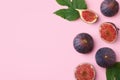 Fresh ripe figs with green leaves on pink background, flat lay. Space for text Royalty Free Stock Photo