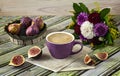 Fresh ripe figs on vintage plate, purple cup of coffee, bouquet of burgundy dahlias, purple shawl as decoration.